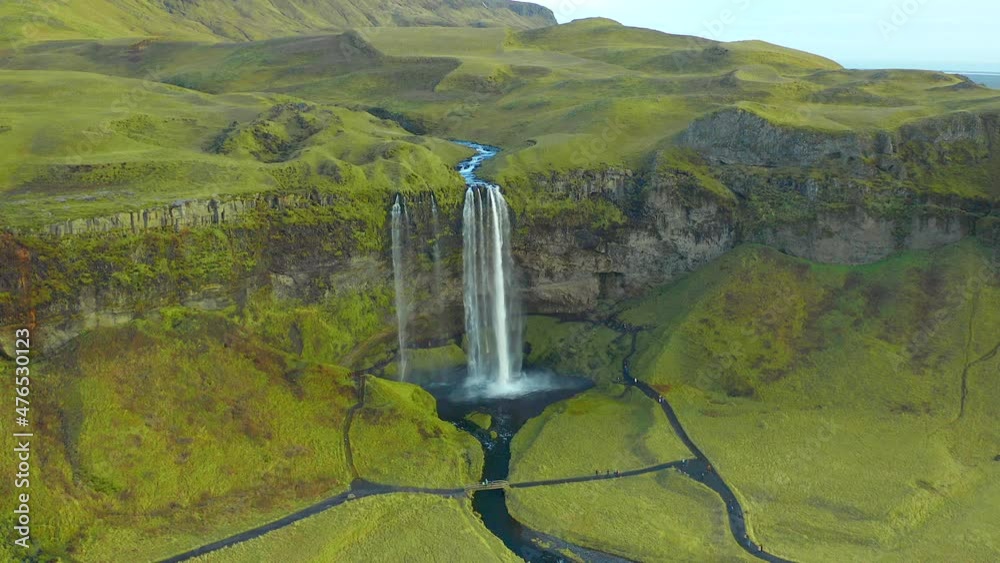 Green scenic Seljalandsfoss waterfall landscape incredible natural landmark view, static drone shot