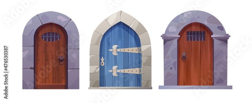 Antique medieval wooden door with metal round handle and lined with stones. Gothic entrance, gate in a castle, church or house.