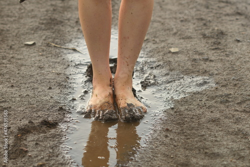 Young girls's muddy feet. Selective focus.