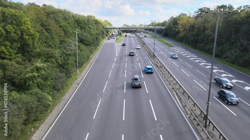  Cars driving on multilane trunk road and stopping to queue on exit ramp.