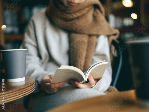 カフェでマフラーを巻き本を読む女性 photo