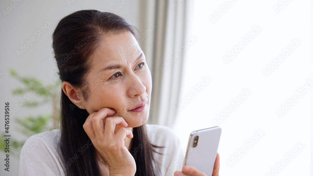 スマホを使うシニア女性