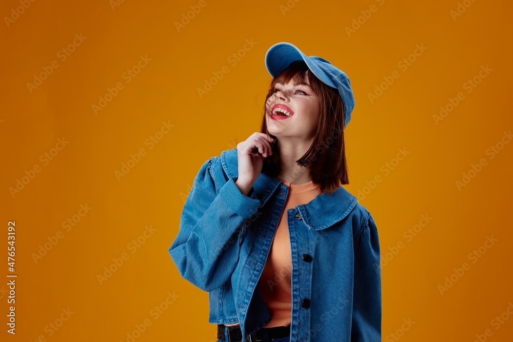 Pretty young female denim cap red lips glamor fashion yellow background unaltered Pretty young female denim cap red lips glamor fashion yellow background unaltered