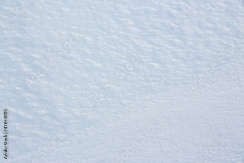 Natural snow texture. Smooth surface of clean fresh snow. Snowy ground. Winter background with snow patterns. Perfect for Christmas and New Year design. Closeup top view. © Andrei Stepanov
