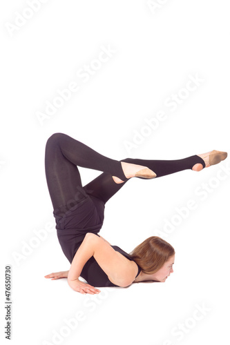 SportConcepts. Caucasian Sportswoman Rhythmic Gymnast In Training Black Outfit Posing Indoors During Backward Legs Twist Stretching Exercises