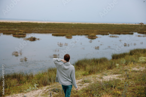 woman in sweater on nature walk landscape