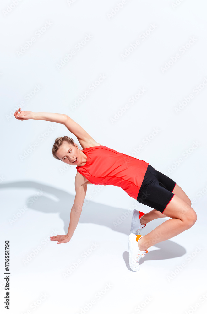 Sport Concepts. Active Female In Jogging Outfit During Body Flex and Stretching Exercises On White Sport Concepts. Active Female In Jogging Outfit During Body Flex and Stretching Exercises On White