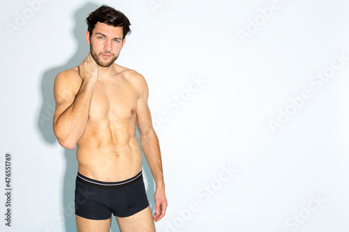 Caucasian Handsome Brunet Man in Black Underware In Good Phyisycal Fit While Posing in Underware Against White Background.
