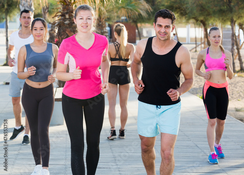 People leading healthy lifestyle, jogging during outdoor workout on city seafront
