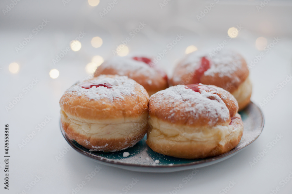 Sufganiyot donuts with icing sugar and red jelly. Israeli jelly donuts for Hanukkah