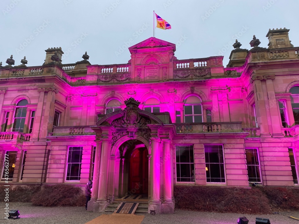 Naklejka premium Large house in Scotland during Christmas illuminated in purple lights