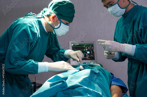 Selective focus at knife. Doctor using operate surgical knife to cut on body part while doing surgery for patient inside of the hospital Male assistance. Healthcare expertise, professional service.