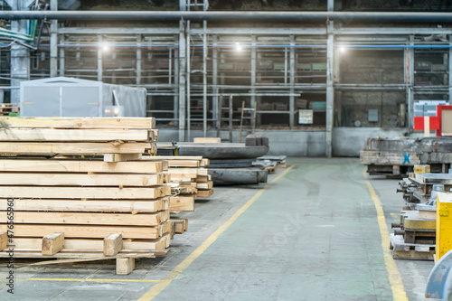 Inside huge woodworking industrial factory workshop interior with stacks of wood.