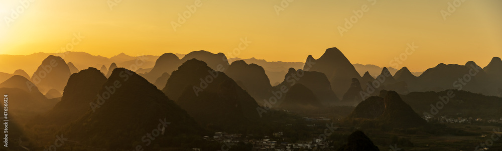 The wide and wide picture, the sunrise silhouette of Guilin landscape in Guangxi, China is like Chinese landscape painting in the style of ink painting	