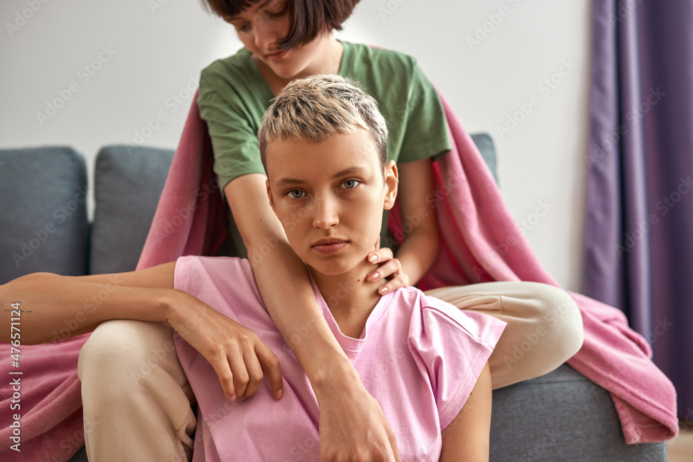 Obraz premium Cropped of girl on sofa hug serious girlfriend