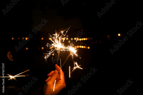 New year fireworks. Celebration with black background. Sparkles in the hand, shining fire.