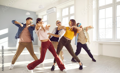 Billede på lærred Overjoyed young diverse dancers team in casual clothes and glasses have fun performing together in studio