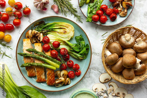 fresh healthy food, vegetables, green asparagus, grilled salmon, fish fillet, cherry tomatoes, green fresh lettuce, spices and herbs, spring dish, mushrooms, top view, seasonal cuisine
