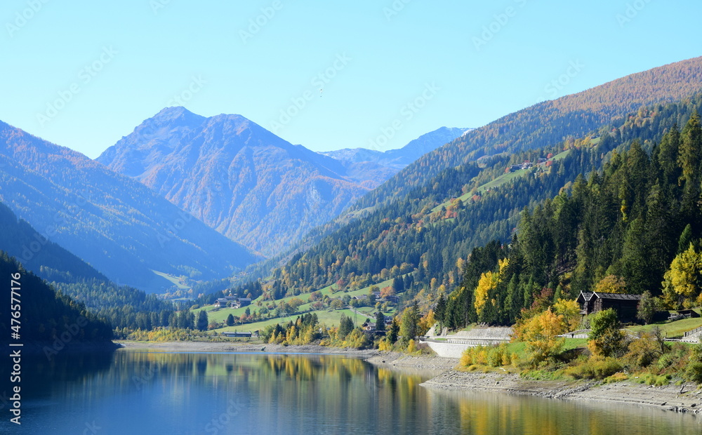 Blick ins hintere Ultental mit Zoggler Stausee, Wäldern mit Herbstfärbung und dem Gebirge im Hintergrund