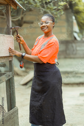 image of beautiful african lady, holding a working tool- outdoor wood work concept