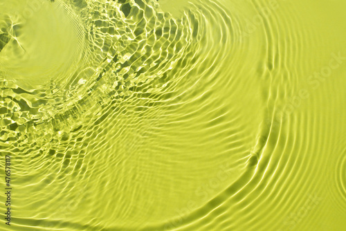 Water spills on a light green yellow background. Natural sunlight and shade. Beautiful bursts and glare. Summer mood. Minimal style.