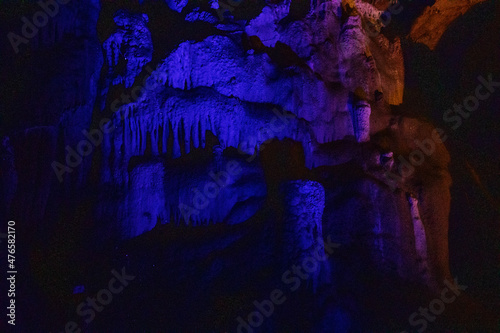 dark blue abstract background of stalactites, stalagmites and stalagnates in the Sfendoni cave, underground,. horizontal