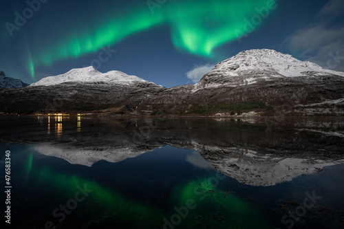 Northern lights landscape (Aurora borealis) reflected in a freezing fjord in northern Norway