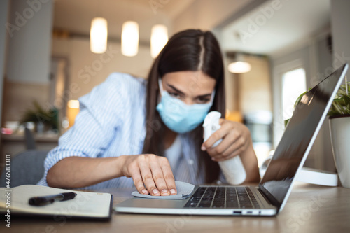 Young woman cleaning with antibacterial disposable wipes during COVID-19 pandemic at home