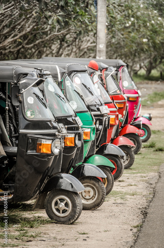 A row of neatly parked tuk tuk auto rickshaws
