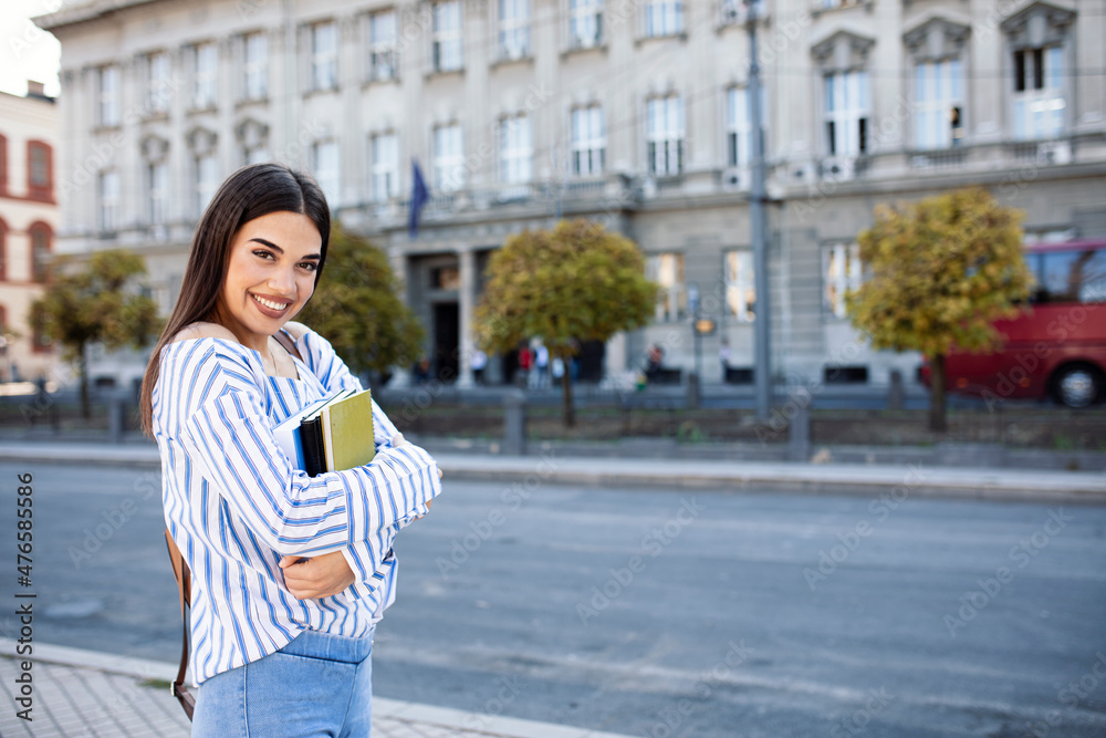 Female college student with books outdoors Female college student with books outdoors