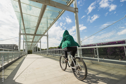 Woman riding bike at city on sunny day