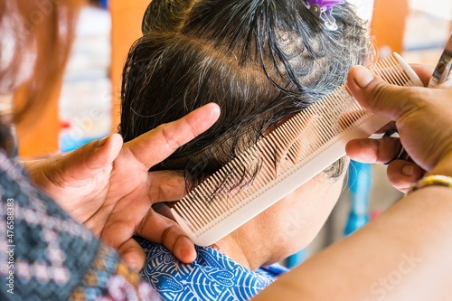 Bangkok, Thailand - November, 14, 2021 : Close-up of the hairdresser cutting female hair cutting scissors at Bangkok, Thailand.
