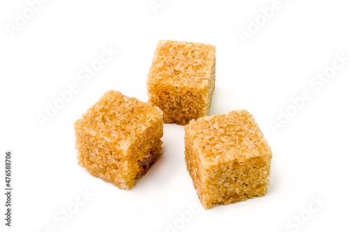 Three cubes of brown sugar with shadow on white background