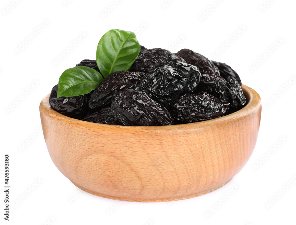 Wooden bowl with sweet dried prunes and green leaves isolated on white Wooden bowl with sweet dried prunes and green leaves isolated on white