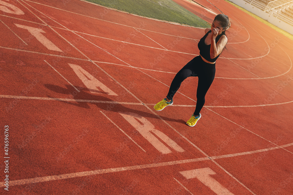 Fit young woman running sprinting at the racetrack. Fit runner fitness runner during outdoor workout with START text at racetrack. Start running concept.