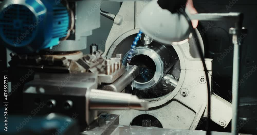 Close-up of a heavy industrial worker's hand working on a metalworking process in a factory, performing a mechanical turning operation on a machine tool for the steel structure industry. Close-up of a heavy industrial worker's hand working on a metalworking process in a factory, performing a mechanical turning operation on a machine tool for the steel structure industry.