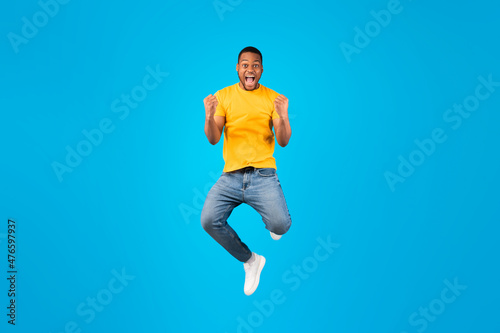 Emotional Black Guy Shouting Gesturing Yes In Mid-Air, Blue Background