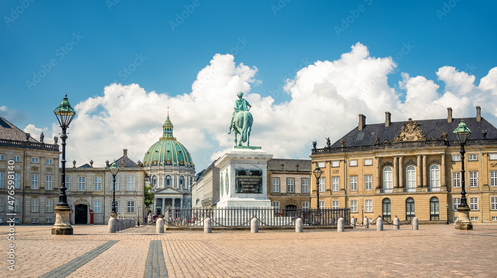 Bronze cast equestrian statue of King Frederik V among palaces in Amalienborg and facade of Frederik's Church in the background, in Copenhagen, Denmark