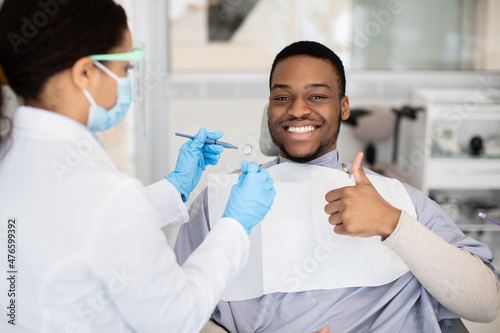 Black Male Patient Showing Thumb Up While Having Check Up With Dentist