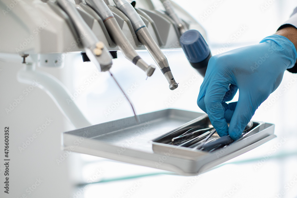 Closeup Shot Of Dentists Hand In Blue Glove Taking Sterile Stomatological Tools Closeup Shot Of Dentists Hand In Blue Glove Taking Sterile Stomatological Tools