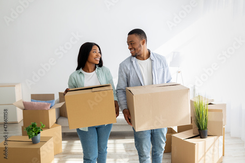 Relocation and apartment rent. Loving african american spouses carrying paper boxes into new house © Prostock-studio