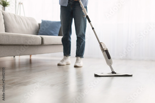 Low section of woman cleaning floor with spray mop