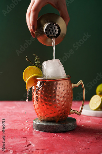 Photography Pouring traditional american alcoholic beverage moscow mule in copper mug with l
