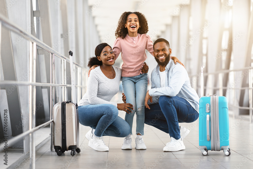 Happy african family traveling, posing together in airport Happy african family traveling, posing together in airport