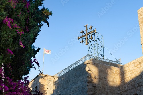 Large cross and flags on the roof of the Church of Nativity building in the central square in the city of Bethlehem in the Palestinian Authority, Israel