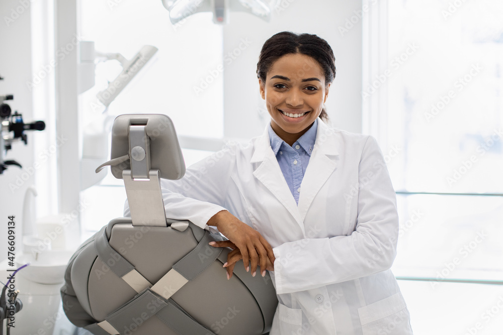 Professional black female stomatologist doctor posing at workplace in modern clinic Professional black female stomatologist doctor posing at workplace in modern clinic