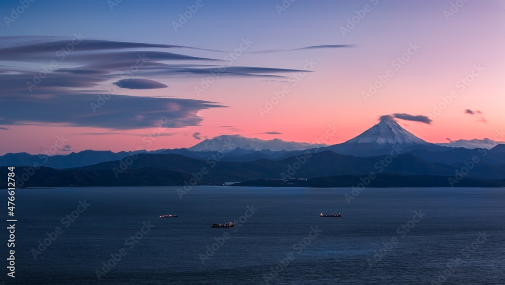 Kamchatka, pink sunseti n the water area of Avachinskaya Bay, Vilyuchinsky volcano in the background.