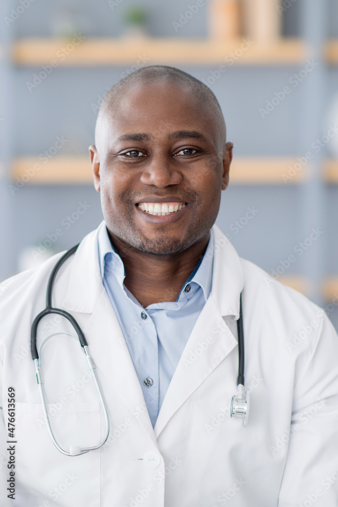 Health care remotely. Portrait of african american doctor in white coat with stethoscope in office interior, crop Health care remotely. Portrait of african american doctor in white coat with stethoscope in office interior, crop