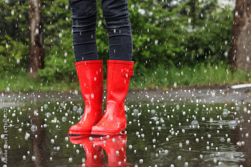 Woman wearing red boots outdoors on rainy day with closeup Stock Photo | Adobe Stock
