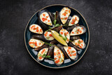 Baked mussels with cheese, salmon, lemon and herbs
